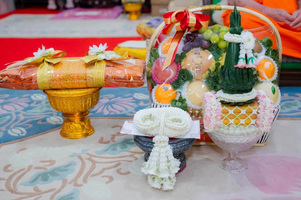 เครื่องสักการะมุทิตาจิต ผ้าไตรจีวร กระเช้าผลไม้ และพวงมาลัยประณีต
